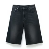 Bermuda de jean negra con lavado oscuro, corte ancho (baggy) y largo hasta la rodilla (3/4). Presenta un dobladillo deshilachado en el ruedo y cierre frontal con botón y cremallera.