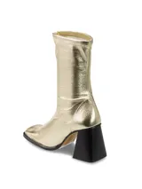 Botas de caña alta color dorado, con tacón cuadrado y punta cuadrada.