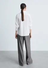 Camisa blanca de popelina de algodón y lyocell, de corte recto, manga larga con puños abotonados y cuello camisero.