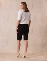 Bermuda color beige en gabardina elastizada, con pretina ancha elastizada, bolsillos simulados en la parte delantera y bolsillos aplicados en la parte trasera.