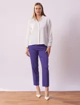 Camisa blanca de gasa, marca Sioni, con cuello con solapa, abertura central con botones y mangas largas con puño y botón.