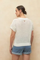 Chaleco tejido color beige con diseño calado, cuello redondo y mangas cortas.