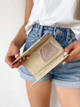 Billetera beige, crema y marrón con cierre de broche y monedero externo.