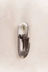 Zapatillas deportivas plateadas con detalles en blanco y suela de goma color caramelo.