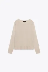 Jersey color beige de punto con cuello redondo y manga larga.