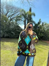 Sweater tejido de lana color azul marino con diseño geométrico en blanco.