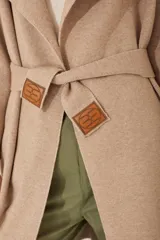 Tapado tejido color marrón con cuello solapa y bolsillos.