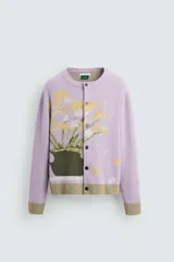 Cárdigan lila con diseño floral, cuello redondo, manga larga, rib en puños y ruedo, y cierre frontal con botones.