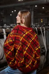 Sweater de lana tejido y bordado a mano en Uruguay, de calce holgado con cuello a la base y puños. Diseño con rombos en tonos rojo, negro, amarillo y marrón.