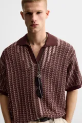 Polo relaxed fit de punto color borgoña con diseño geométrico en beige. Cuello solapa con abertura frontal, manga corta y acabados en rib.