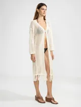 Cárdigan largo de algodón color crudo, tejido con punto abierto y detalles de flecos en el ruedo.