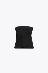 Top negro strapless de tejido fluido con frunces ajustables con cordones en los laterales y aberturas laterales en el ruedo.