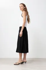 Falda midi cruzada color negro, confeccionada en lino.