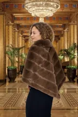Poncho marrón de piel sintética con cuello y diseño de franjas horizontales.