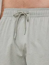 Short de baño verde agua texturizado con cintura elástica y cordón ajustable.