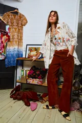 Camisa holgada color crema con bordados de palmeras y frutos, confeccionada en algodón. Presenta terminación de puntilla en el ruedo.