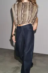 Pantalón de jean azul oscuro, de tiro alto, corte ancho y largo hasta el tobillo.