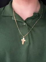 Dije de acero quirúrgico dorado con forma de cruz clásica bombé y terminación pulida.