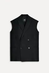 Chaleco negro oversize con cuello solapa de muescas y manga sisa. Tiene falsos bolsillos de vivo en delantero, forro interior a tono y abertura en la espalda. El cierre frontal es cruzado con botones.