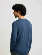 Buzo de punto azul con escote en V y mangas largas.