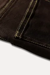 Pantalón de jean marrón oscuro, de tiro alto, corte slim fit y bootcut, con cinco bolsillos y pespuntes a contraste.