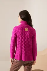 Polera negra de punto con cuello alto y tejido texturizado.