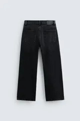 Pantalón de jean negro con corte flare y estilo baggy, con cinco bolsillos, efecto lavado y cierre frontal con botones.