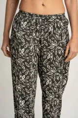 Pantalón recto con estampado de hojas color blanco sobre fondo negro, con cintura elástica y bolsillos laterales.