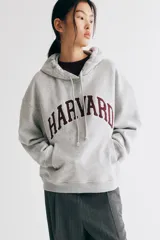 Canguro gris con capucha y cordones ajustables, bolsillo tipo canguro y puños y bajo acanalados. Estampado frontal con el nombre "Harvard" en color bordó.