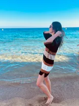 Vestido corto tejido en hilado de algodón con rayas horizontales en negro, tostado y blanco.