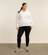 Campera deportiva femenina cortaviento, modelo alargada con capucha, cierre frontal con cremallera y saquito para guardar.