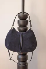 Cartera de cuero negra con doble correa desmontable, una corta y otra larga.