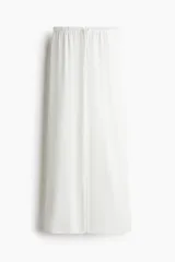 Pantalón de pierna amplia color blanco, confeccionado en punto suave, con elástico revestido y cordón para ajustar en la cintura.