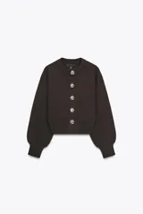 Chaqueta de punto marrón oscuro con cuello redondo y manga larga abullonada. Cierre frontal con botones metálicos plateados con diseño de rosa.