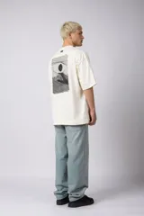 Remera negra de corte oversize con cuello redondo y mangas cortas. Estampado pequeño en el frente y parche estampado en la espalda.