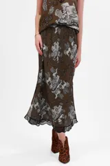 Falda midi color verde oscuro con estampado de ángeles y edificios en tonos grises, con elástico en la cintura y detalle de puntilla negra en el ruedo.
