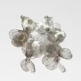 Par de caravanas colgantes plateadas con forma de flores y detalle de perla colgante.