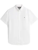 Camisa blanca de lino de manga corta con cuello abotonado y logo de Tommy Hilfiger bordado en el pecho.