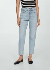 Pantalón de jean celeste de tiro alto, corte mom fit, con cinco bolsillos, trabillas y cierre de cremallera con botón.