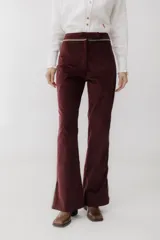 Pantalón de pana marrón con corte acampanado y abertura en el ruedo.