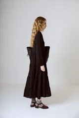 Vestido midi negro con corte en la cintura y falda amplia con volados.