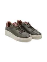 Sneaker Adelaida de cuero graneado color verde oliva, con cordones de algodón y suela elevada color crema.