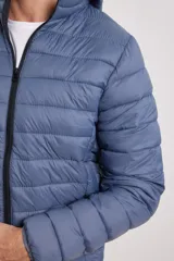 Campera capitoneada color bordó con capucha desmontable con cierre, dos bolsillos exteriores con cierre y un bolsillo interior.