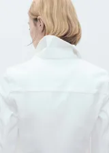 Chaqueta corta de jean blanca con cuello de solapa, dos bolsillos laterales y dos bolsillos de parche con solapa en el pecho.