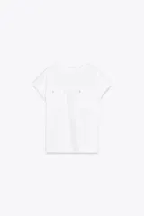 Camiseta blanca de algodón con cuello redondo, manga corta con dobladillo y dos bolsillos de parche en el frente con detalle de aplicación metálica.
