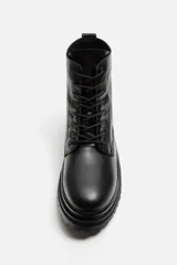 Bota de cuero negra con cordones, caña media y suela track.