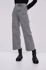 Pantalón jean gris de corte ancho y tiro alto, con terminación desflecada en el ruedo.