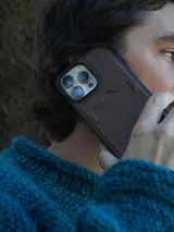 Funda de cuero marrón para iPhone con tarjetero en la parte posterior y logo de la marca Sierra Mora grabado en la parte inferior.