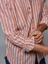 Camisa de lino color cobre con rayas verticales blancas, de manga larga y corte clásico.