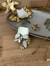Aros colgantes hechos a mano en alpaca plateada con detalles de hojitas de nácar.